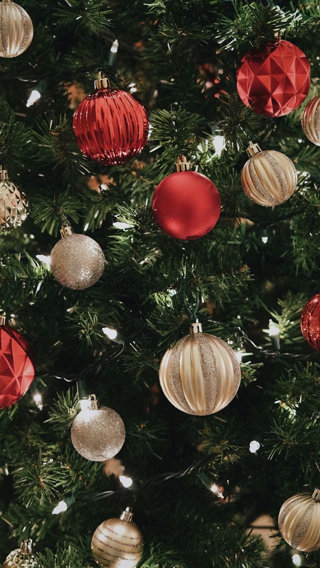 1290x2796 a close up of a christmas tree with ornaments - christmas iPhone Wallpaper