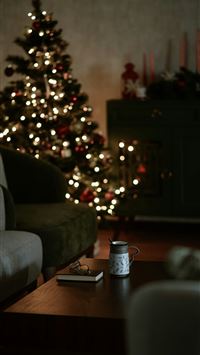 a living room with a christmas tree in the backgro... wallpaper