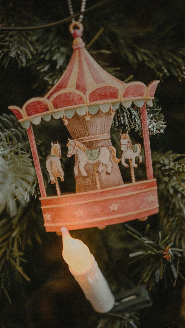 1290x2796 a christmas ornament hanging from a christmas tree - holiday iPhone Wallpaper