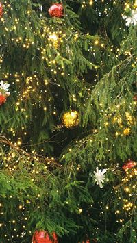 a close up of a christmas tree with lights wallpaper