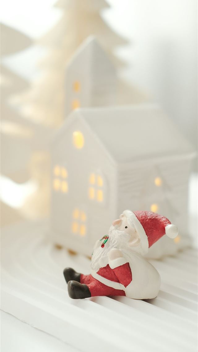 1290x2796 A santa clause figurine sitting in front of a chri... - christmas iPhone Wallpaper