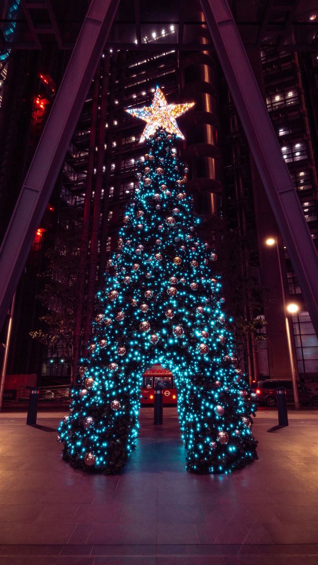 1290x2796 a lit christmas tree in a large building - christmas iPhone Wallpaper