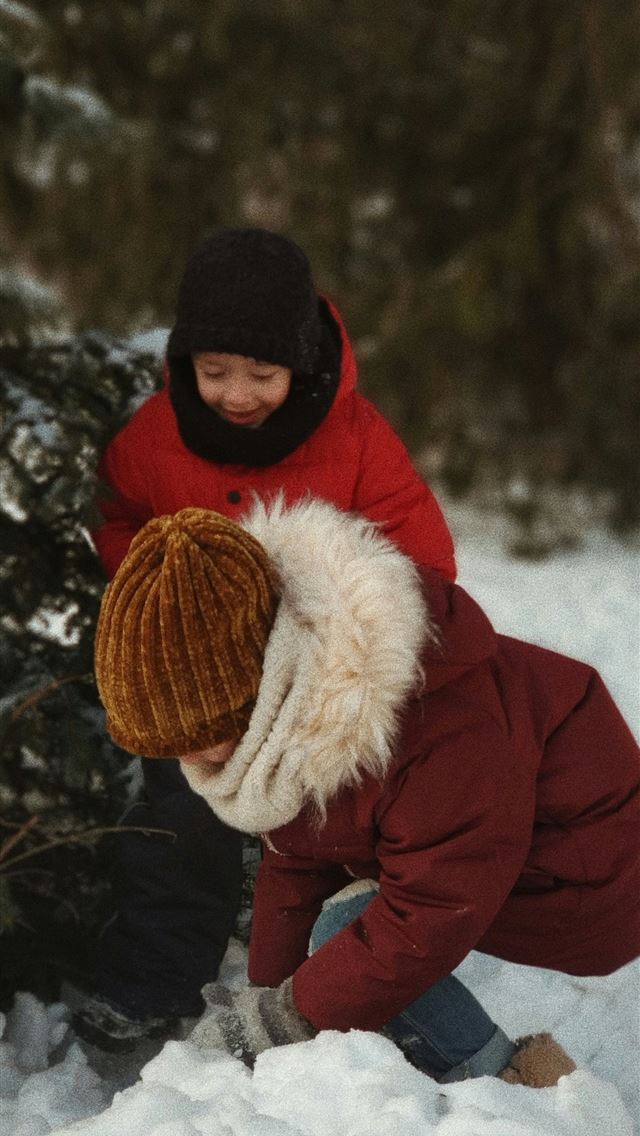 1290x2796 two children playing with snow near tree - christmas iPhone Wallpaper