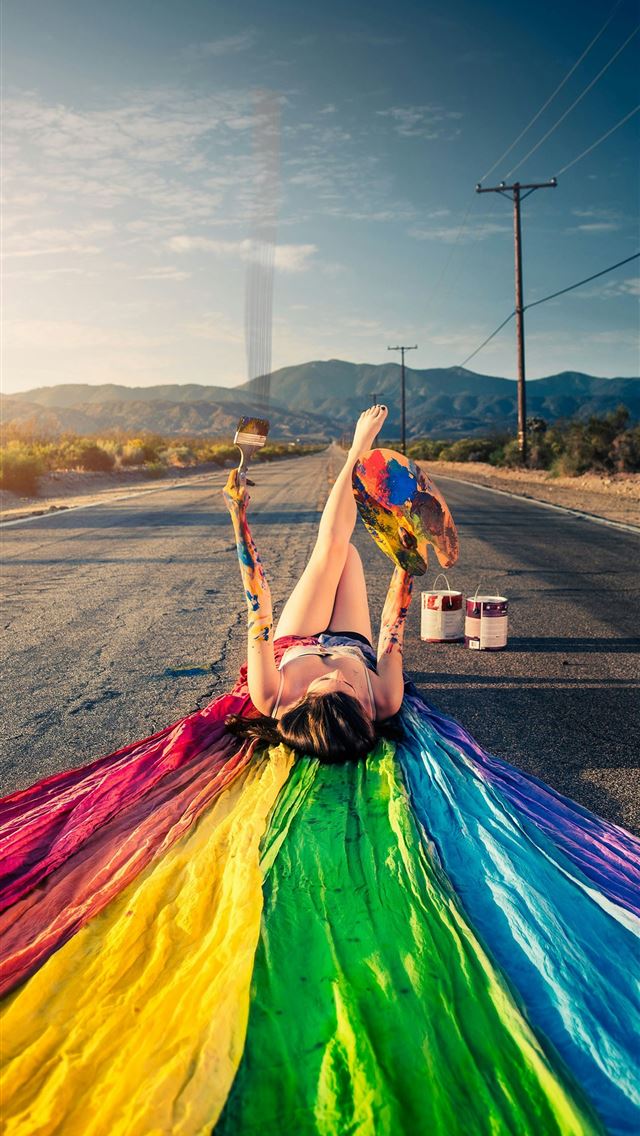 1290x2796 woman lying on road with multicolored textile duri... -  iPhone Wallpaper