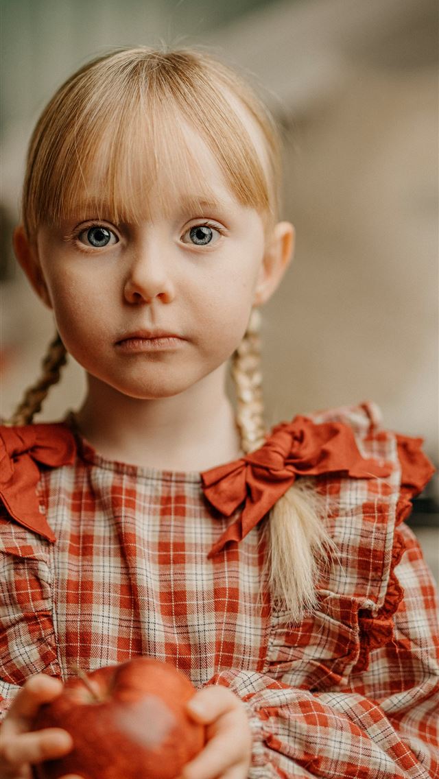 1290x2796 a little girl holding an apple with a sad look on ... -  iPhone Wallpaper
