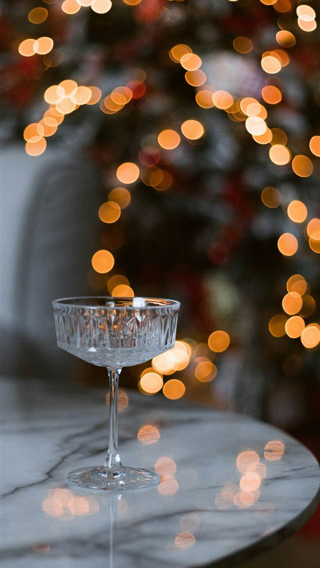 1290x2796 a glass of wine on a table with a christmas tree i... -  iPhone Wallpaper