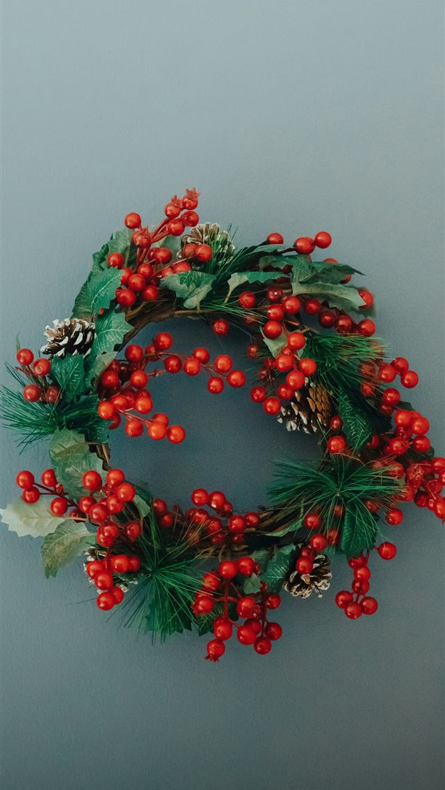 1290x2796 a christmas wreath with red berries and pine cones -  iPhone Wallpaper