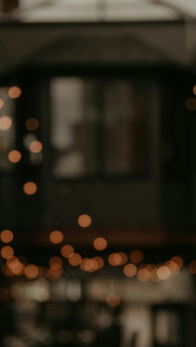 1290x2796 a blurry photo of a building with lights in the ba... -  iPhone Wallpaper