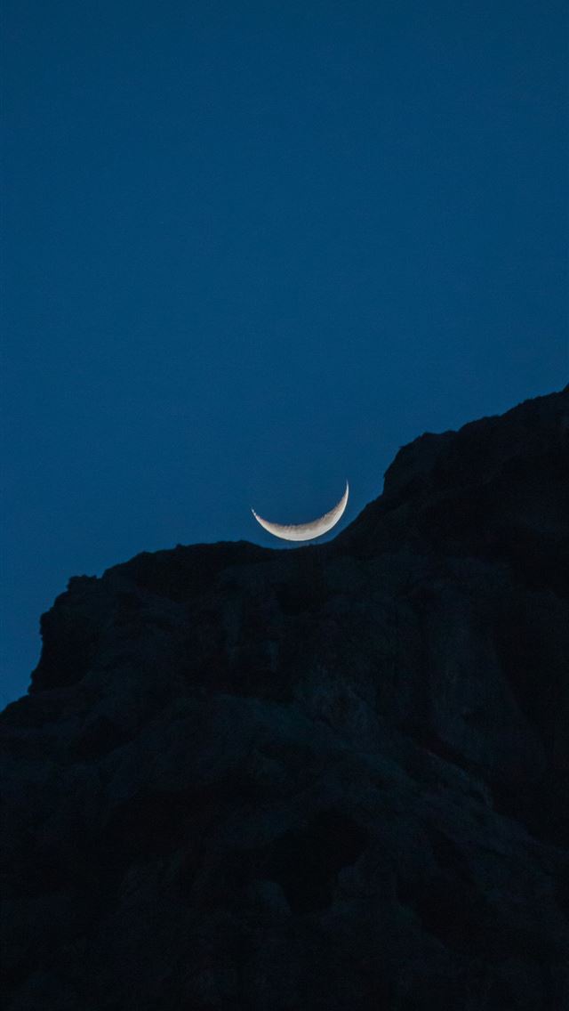 1290x2796 The crescent moon rests atop a dark mountain  -  iPhone Wallpaper