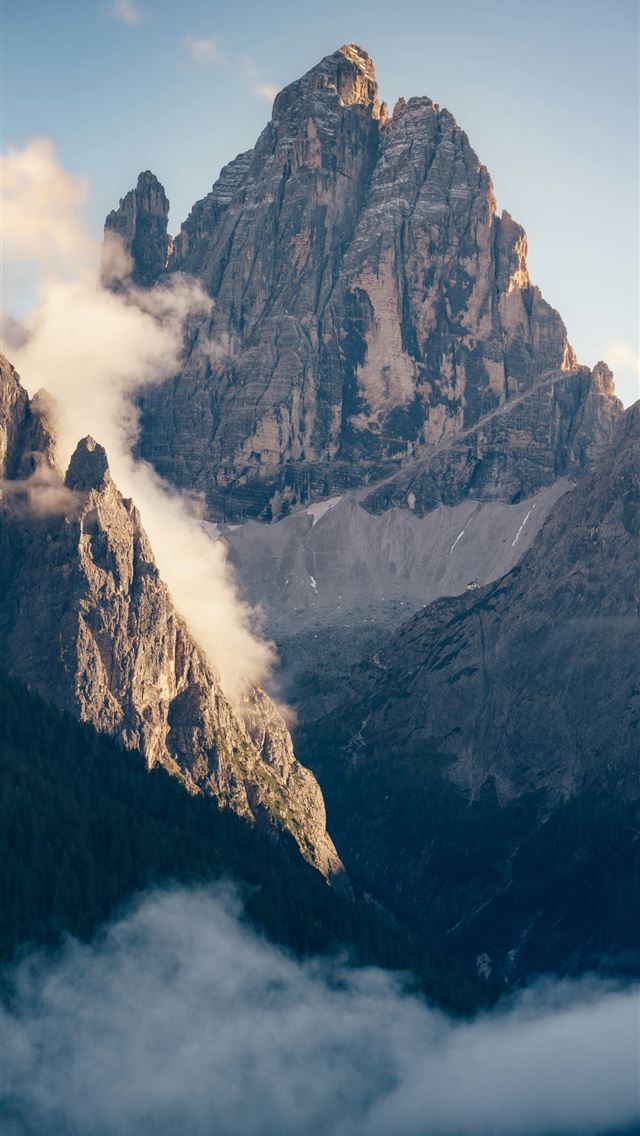 1290x2796 A mountain range covered in fog and clouds -  iPhone Wallpaper