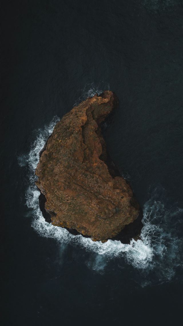 1290x2796 An aerial view of a rock formation in the ocean -  iPhone Wallpaper