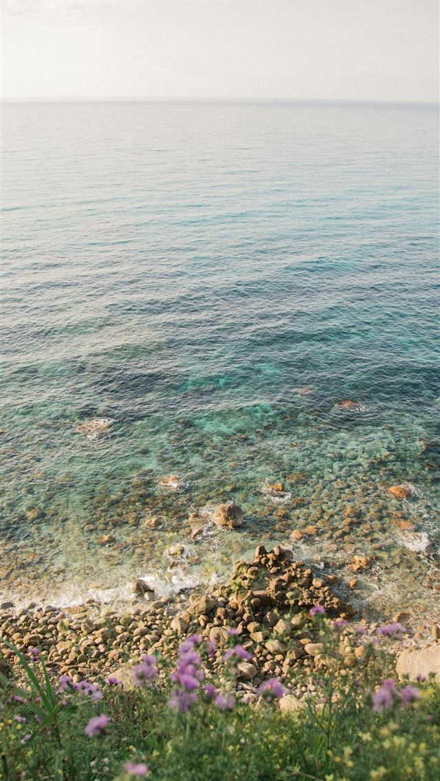 1290x2796 A view of a body of water from a hill -  iPhone Wallpaper