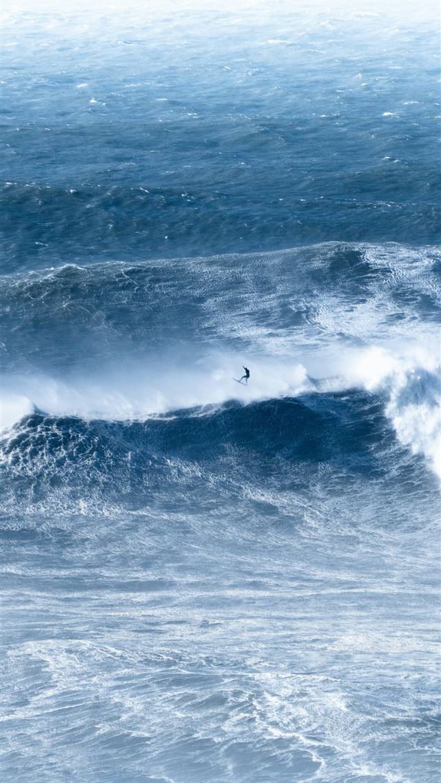 1290x2796 A man riding a wave on top of a surfboard -  iPhone Wallpaper