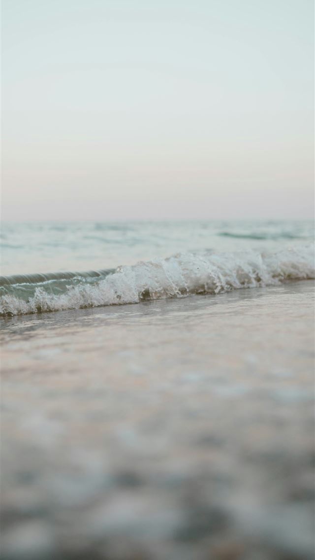 1290x2796 A blurry photo of a wave coming in to the shore -  iPhone Wallpaper