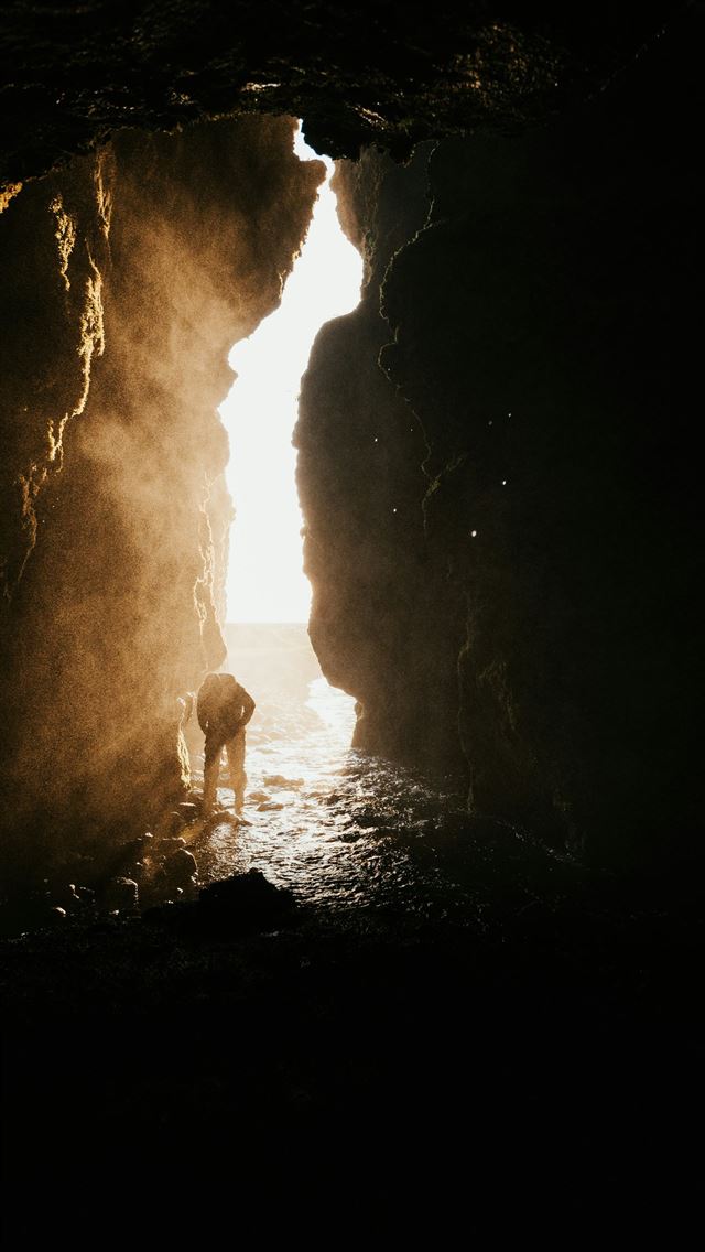 1290x2796 A person standing in a cave with a dog -  iPhone Wallpaper