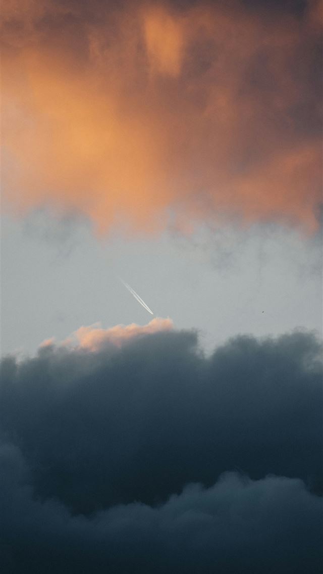 1290x2796 A plane flying through a cloudy sky at sunset -  iPhone Wallpaper