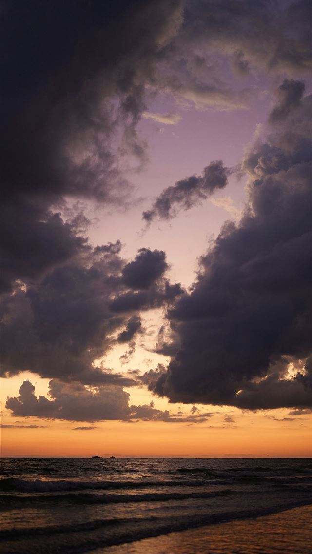 1290x2796 The sun is setting over the ocean on a cloudy day -  iPhone Wallpaper
