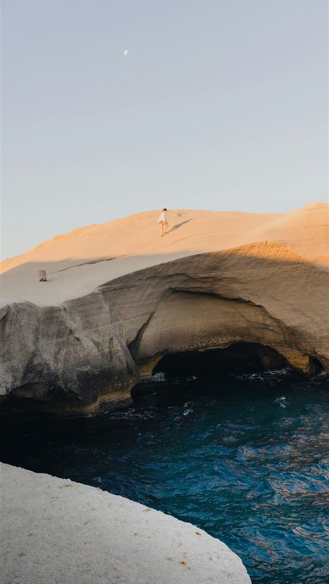 1290x2796 a large rock arch over a body of water -  iPhone Wallpaper