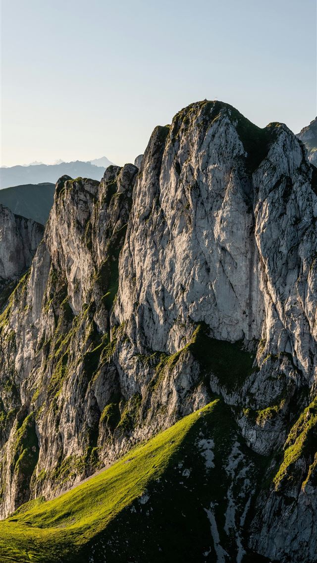 1290x2796 a grassy area in the middle of a mountain range -  iPhone Wallpaper
