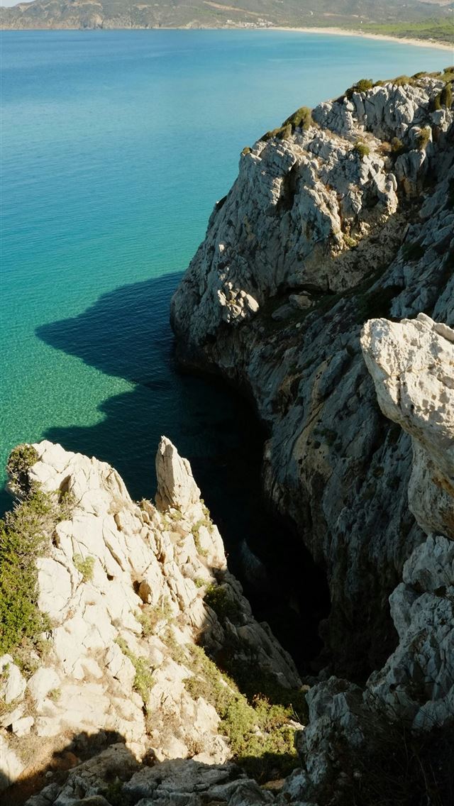 1290x2796 A large body of water surrounded by rocks -  iPhone Wallpaper