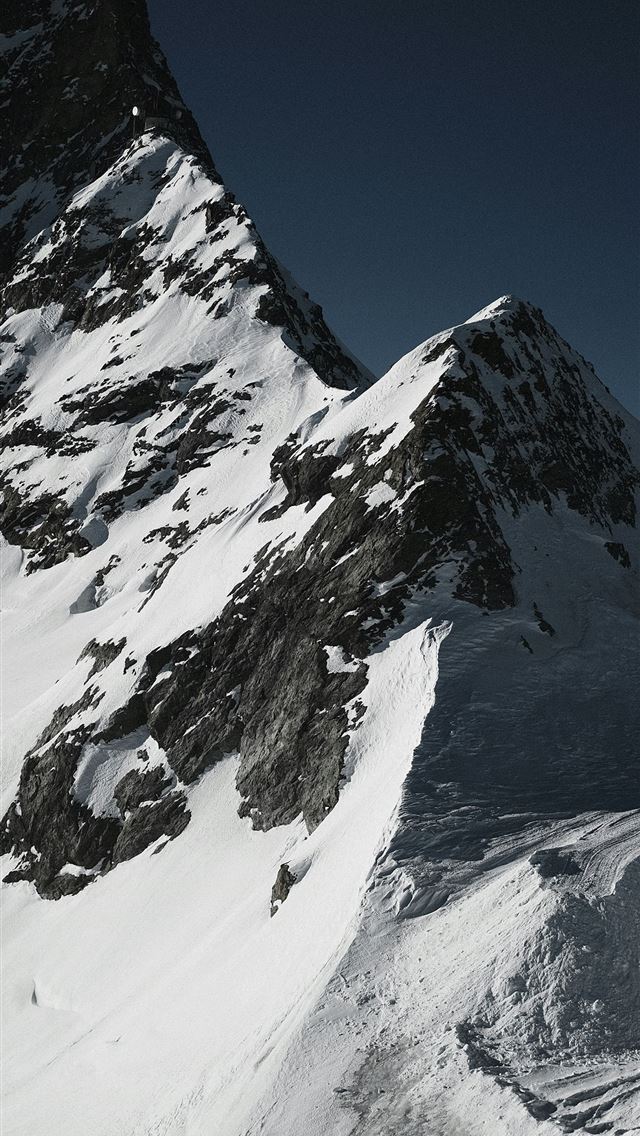 1290x2796 a man riding skis down the side of a snow covered ... -  iPhone Wallpaper