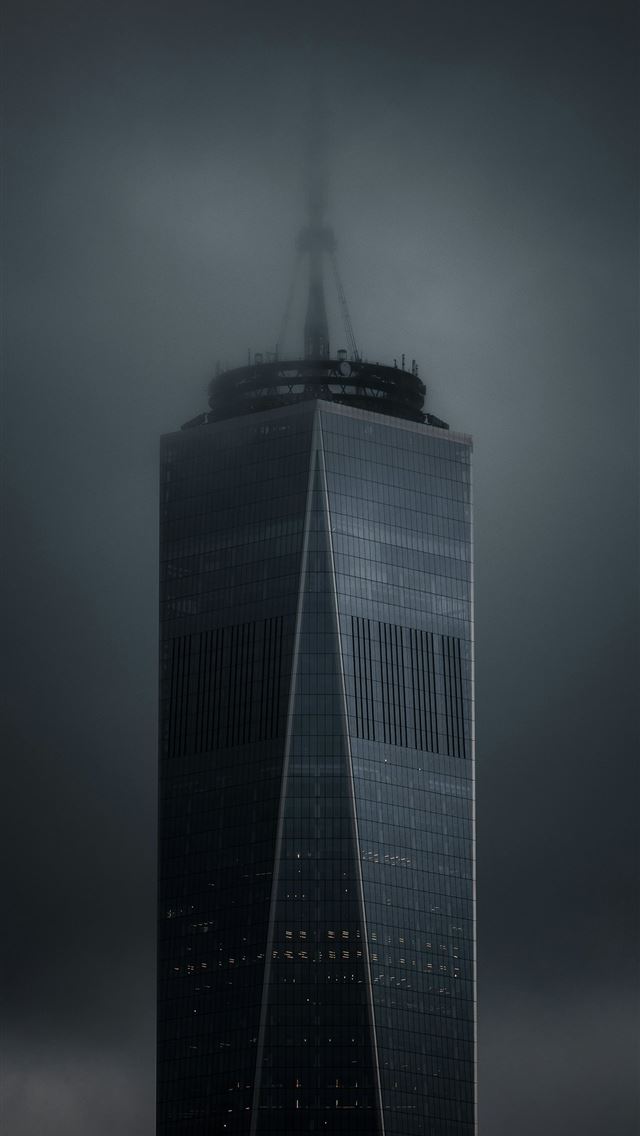 1290x2796 A very tall building with a very dark sky behind i... -  iPhone Wallpaper