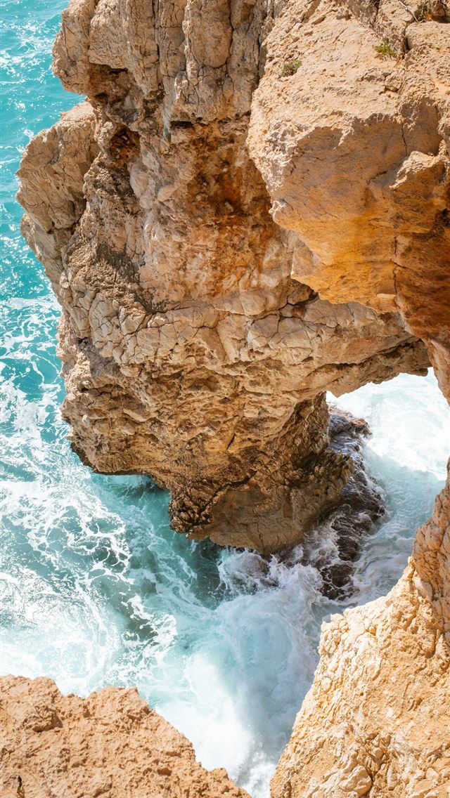 1290x2796 a rocky cliff with a hole in the middle of it -  iPhone Wallpaper