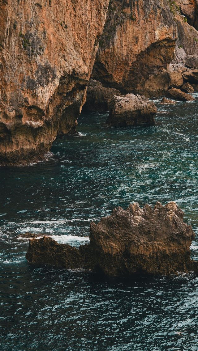 1290x2796 A couple of large rocks sitting on top of a body o... -  iPhone Wallpaper
