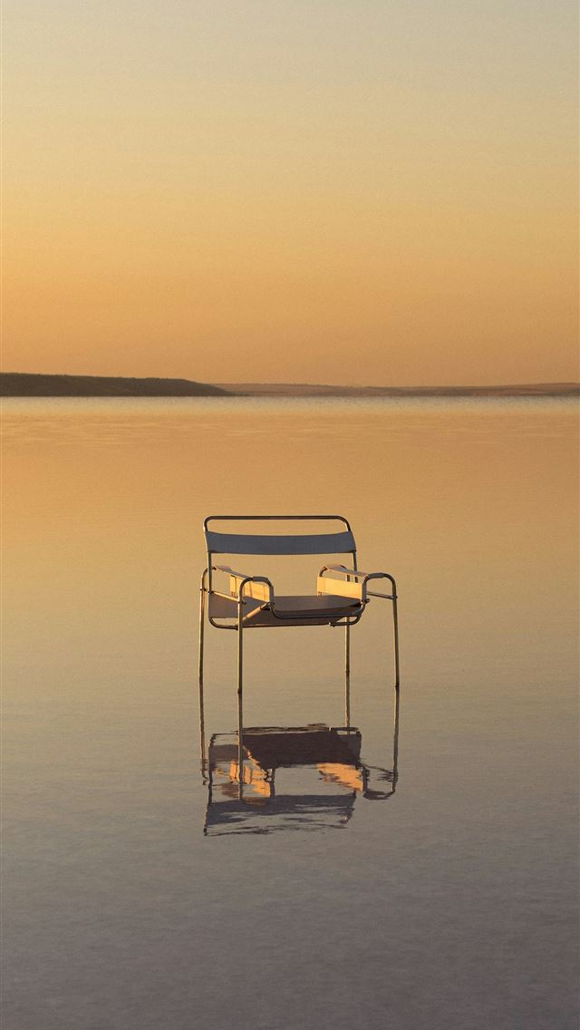 1290x2796 A single chair floats on calm water at sunset  -  iPhone Wallpaper