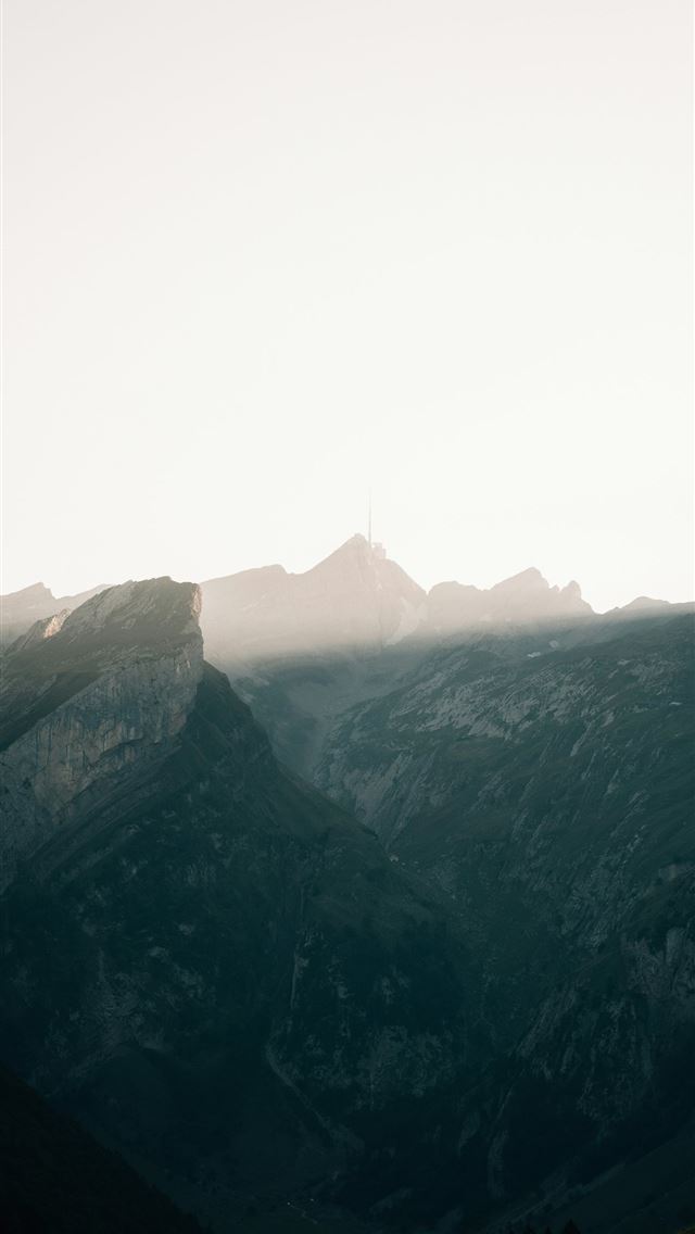 1290x2796 Sunlight breaking through mountain peaks at dawn -  iPhone Wallpaper