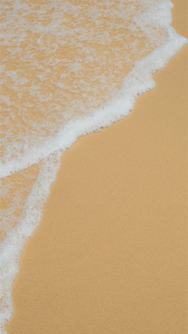 1290x2796 Foam from waves wash onto a sandy beach  -  iPhone Wallpaper