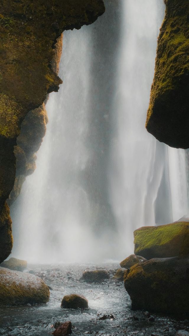 1290x2796 A waterfall is seen from the inside of a cave -  iPhone Wallpaper