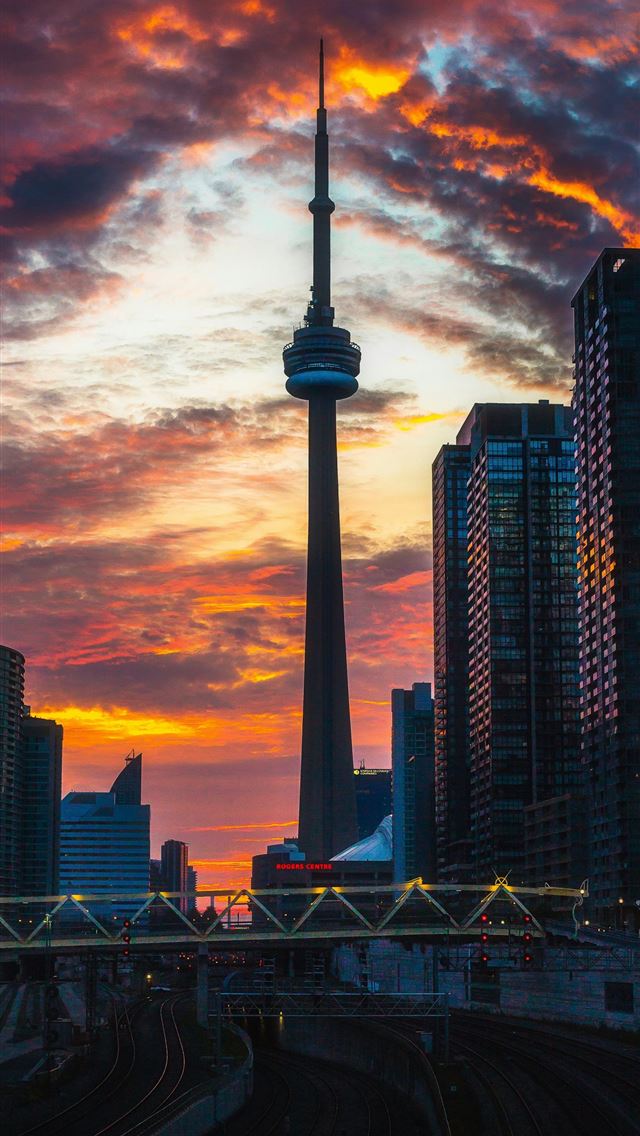 1290x2796 a city skyline at sunset with a train track in the... -  iphone 14 Wallpaper