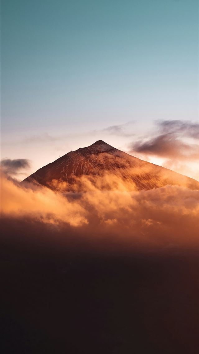 1290x2796 a mountain covered in clouds at sunset -  iPhone Wallpaper