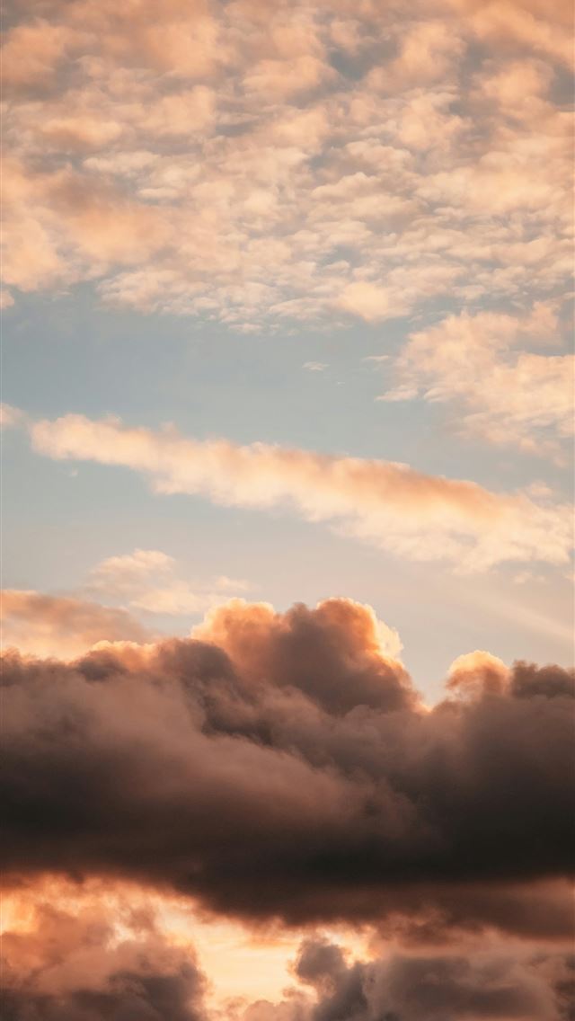 1290x2796 a plane flying through a cloudy sky at sunset -  iPhone Wallpaper