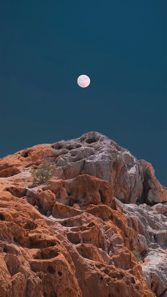1290x2796 a full moon is seen above a rocky outcropping -  iPhone Wallpaper