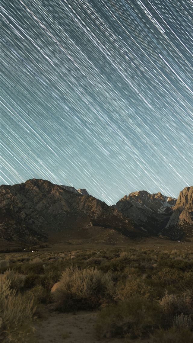 1290x2796 a mountain range with a star trail in the sky -  iPhone Wallpaper