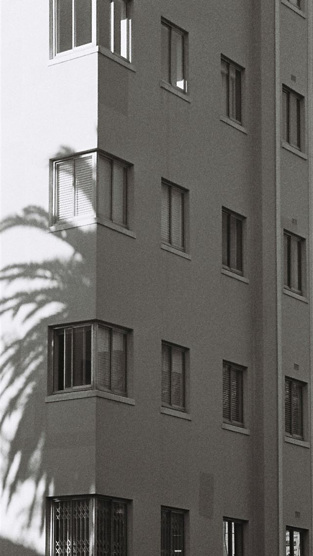 1290x2796 a black and white photo of a tall building -  iPhone Wallpaper