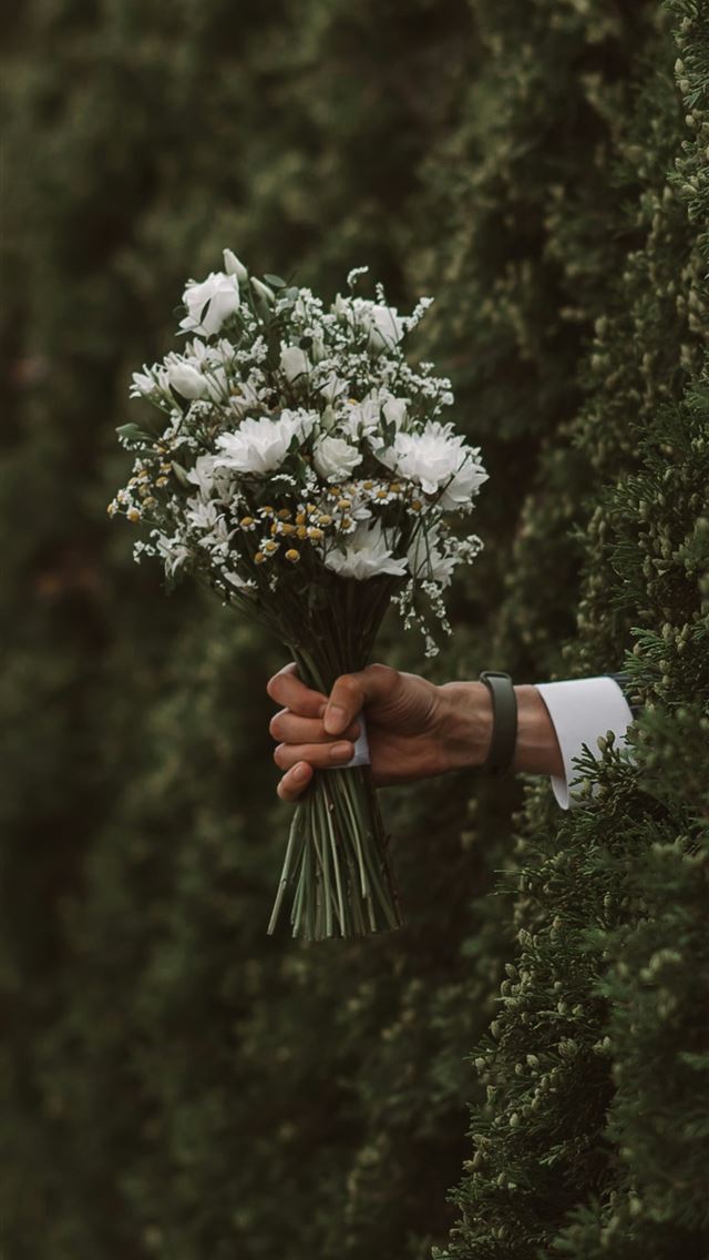 1290x2796 a person holding a bunch of flowers in their hand -  iPhone Wallpaper