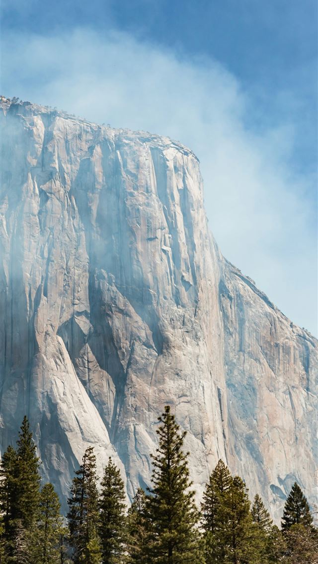1290x2796 a tall mountain with a forest below it -  iPhone Wallpaper