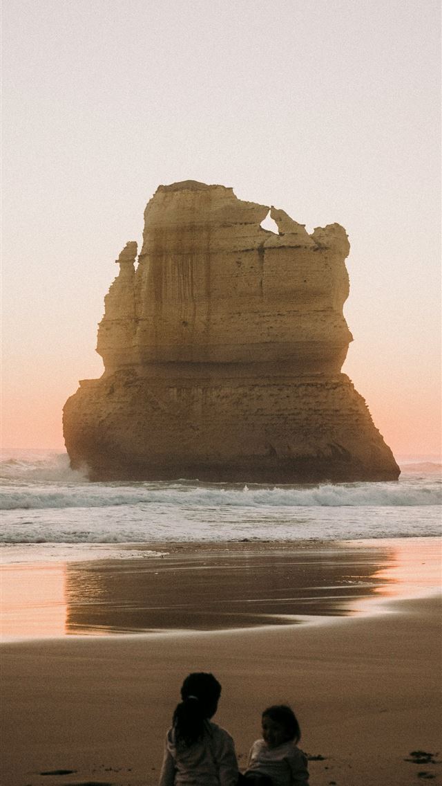1290x2796 two children sitting on the beach watching the sun... -  iPhone Wallpaper