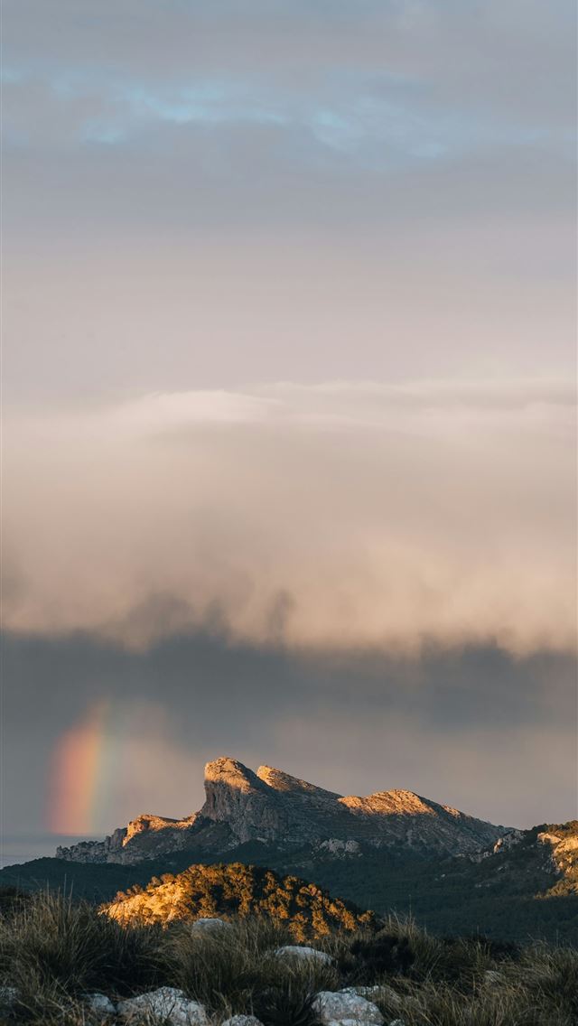 1290x2796 a rainbow in the sky over a mountain range -  iPhone Wallpaper
