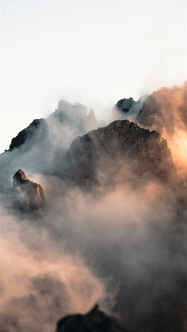 1290x2796 Misty mountain peaks at sunrise with warm light  -  iPhone Wallpaper