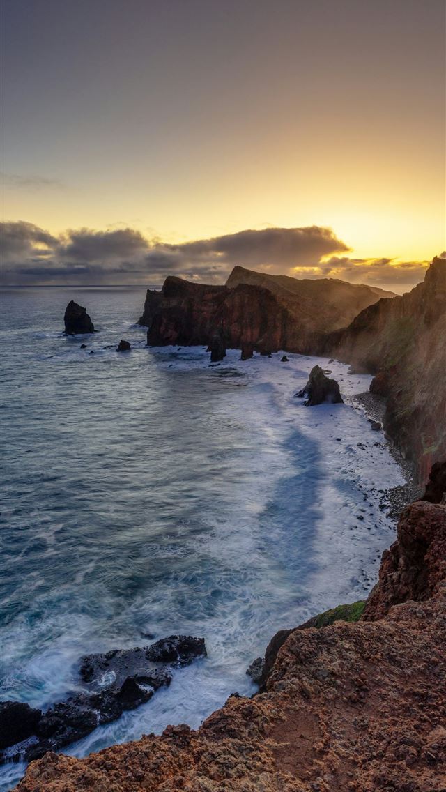 1290x2796 the sun is setting over the ocean near a rocky sho... -  iPhone Wallpaper