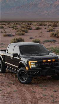 a black truck parked in the middle of a desert wallpaper