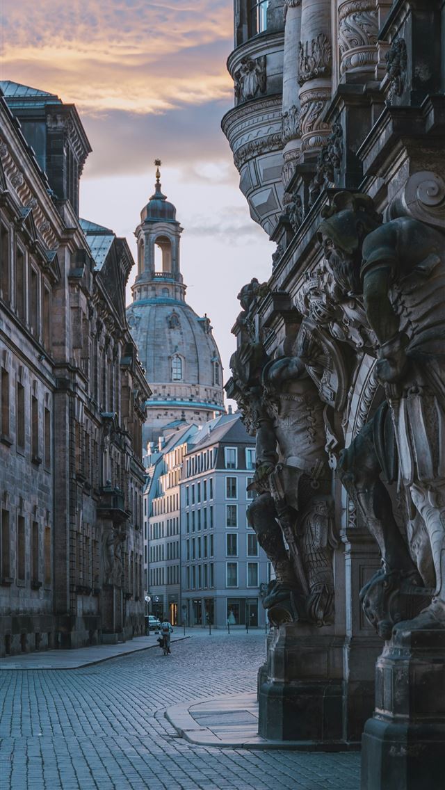 1290x2796 a cobblestone street lined with buildings and stat... -  iPhone Wallpaper