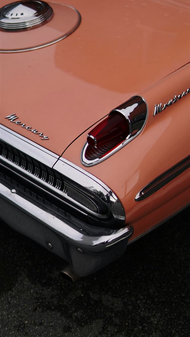 1290x2796 an orange car parked in a parking lot -  iPhone Wallpaper