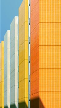 a row of yellow and grey buildings against a blue ... wallpaper