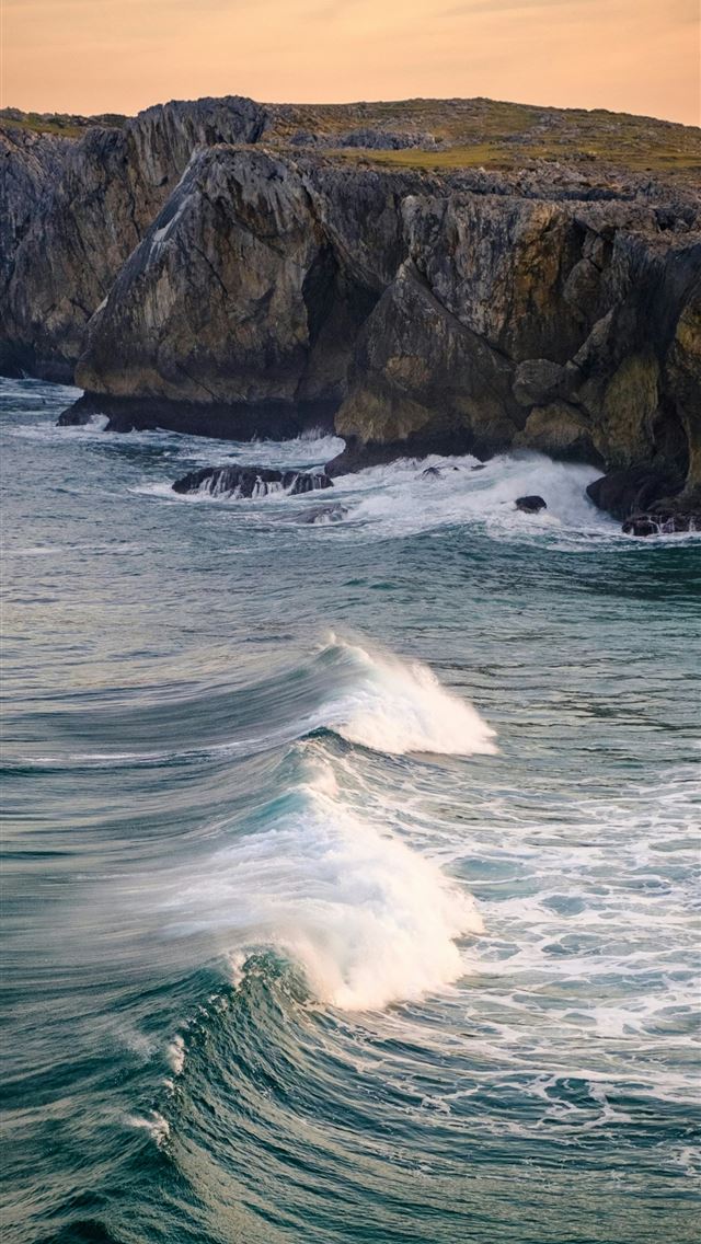 1290x2796 a large body of water next to a rocky cliff -  iPhone Wallpaper