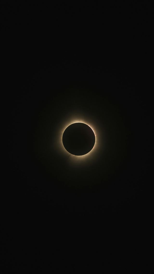1290x2796 a solar eclipse is seen in the dark sky -  iPhone Wallpaper
